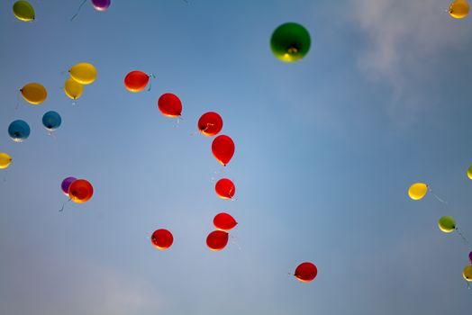 Vibrant balloons ascending against a clear blue sky, symbolizing celebration and joy.