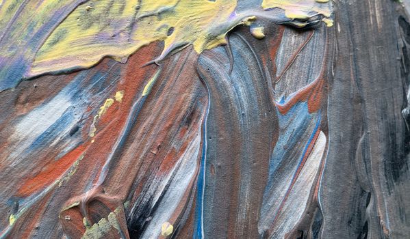 A close-up view of vibrant acrylic paint textures showcasing abstract patterns and brush strokes.