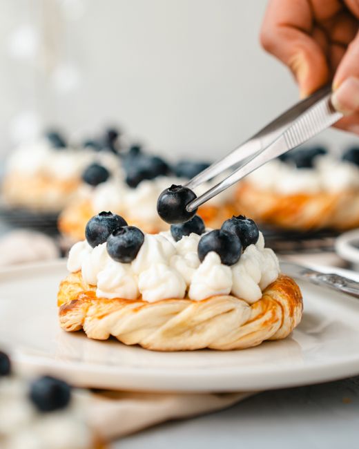 Mouthwatering blueberry pastry with whipped cream, ideal for bakeries and food blogs.