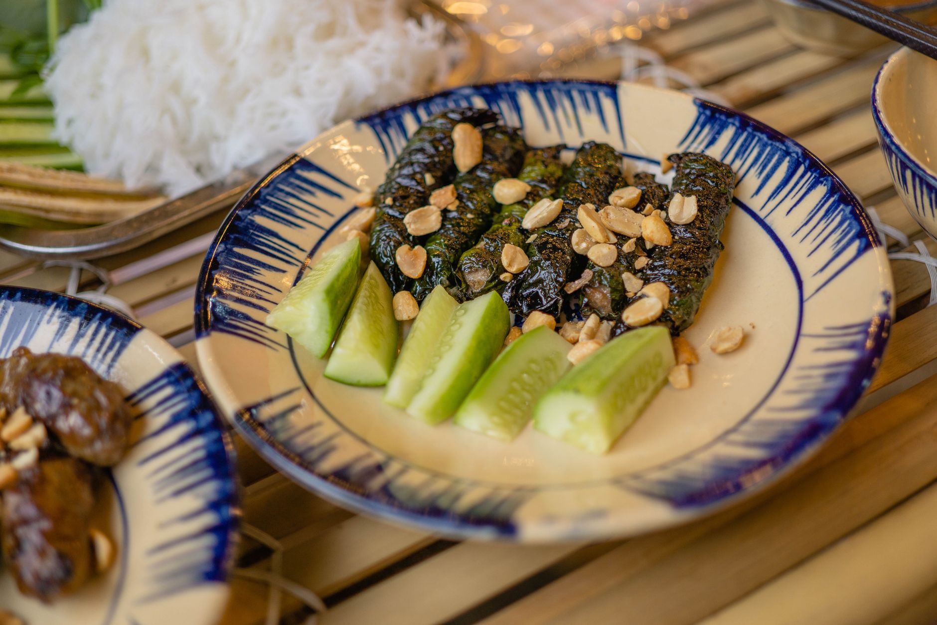 Delicious Bo La Lot dish served with fresh cucumber slices and peanuts. Perfect for Vietnamese cuisine lovers.