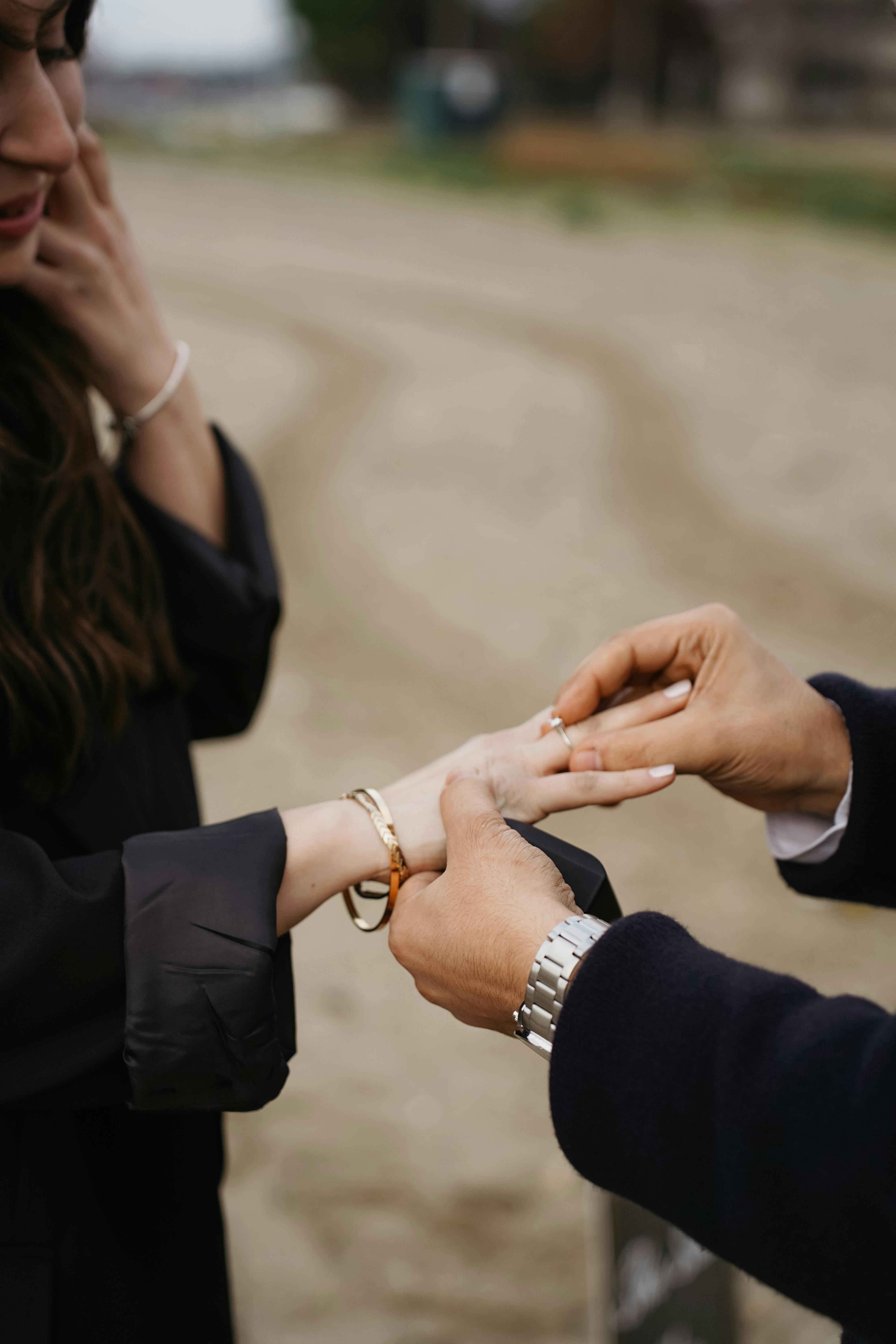 Close-up of a romantic ring exchange during an outdoor marriage proposal.