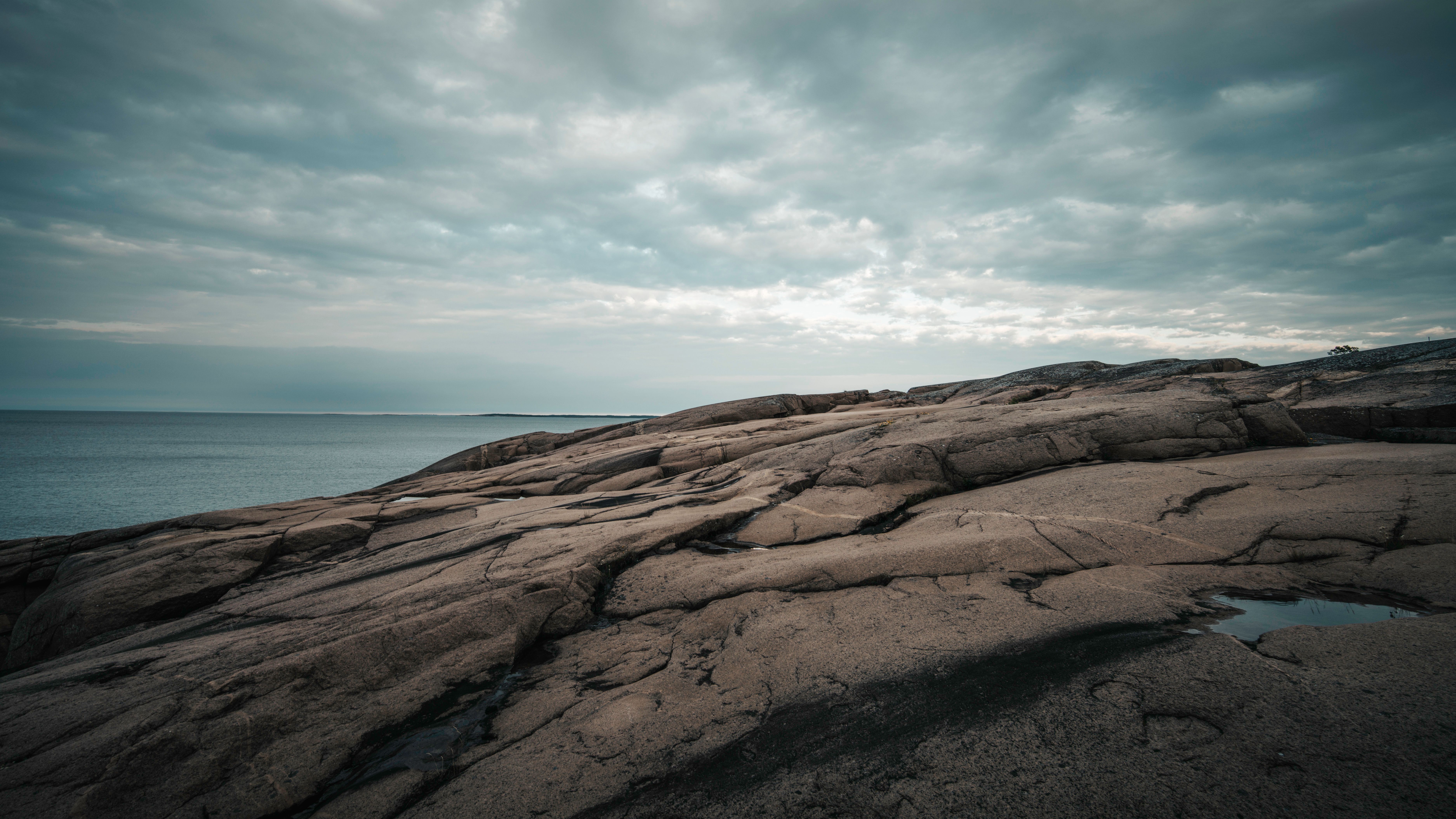Serene rocky coastline with overcast skies on the Åland Islands, a natural wonder.