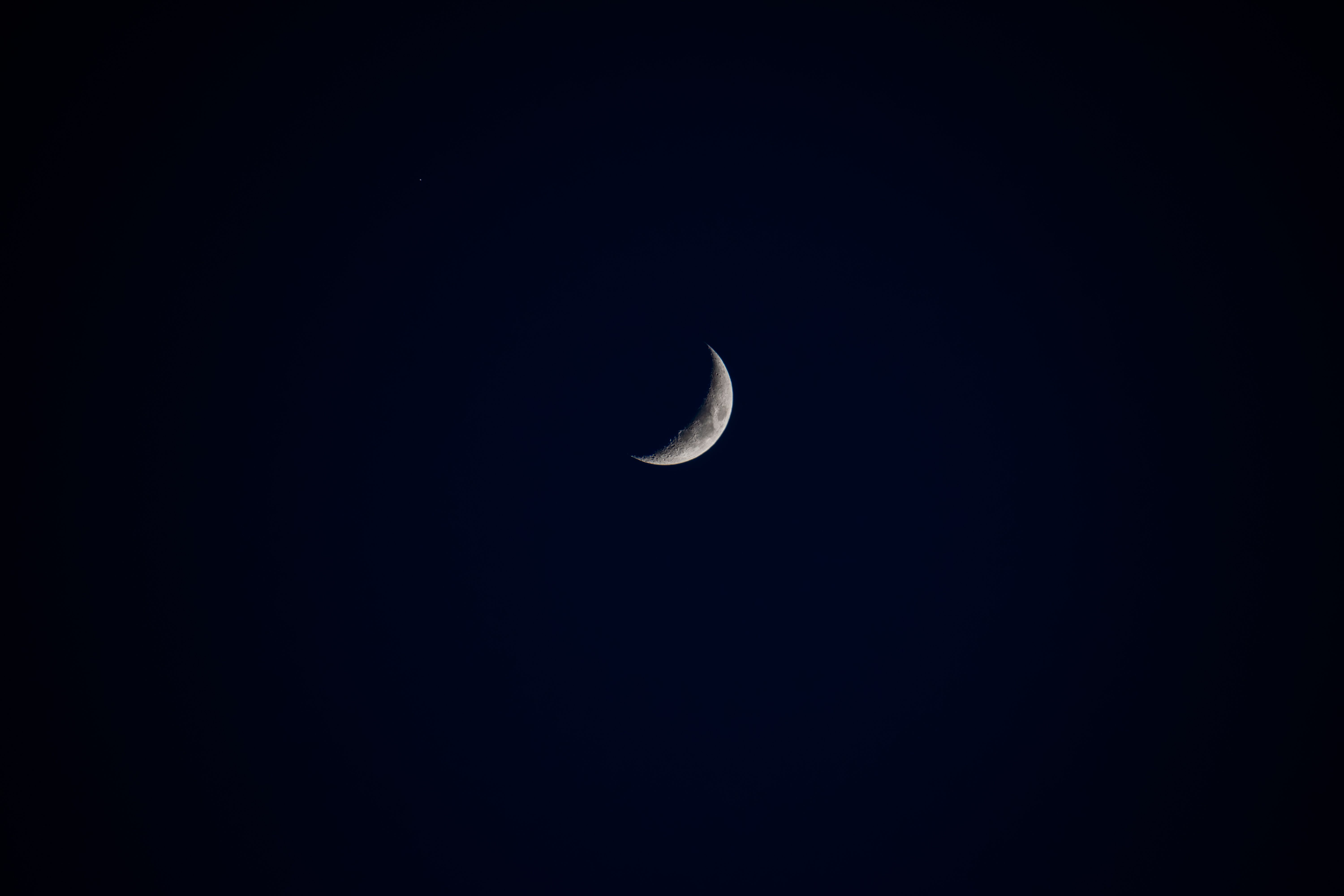 La superficie lunar extendiéndose hacia el horizonte bajo un cielo oscuro