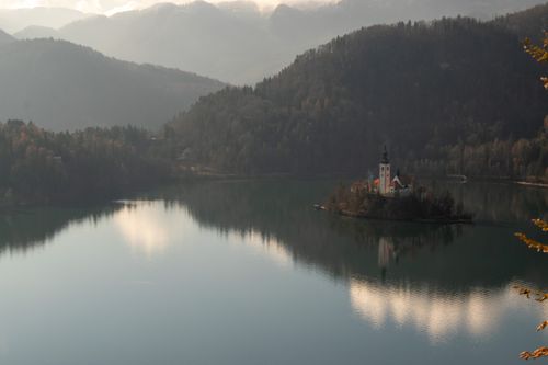Free Picturesque view of Lake Bled with the iconic Church on Bled Island reflecting on calm waters. Stock Photo