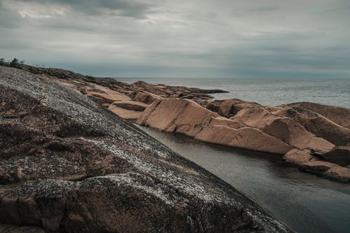 Zadarmo Náladový pohľad na skalnaté pobrežie a pokojné more pod zatiahnutou oblohou na Alandských ostrovoch. Fotka z fotobanky