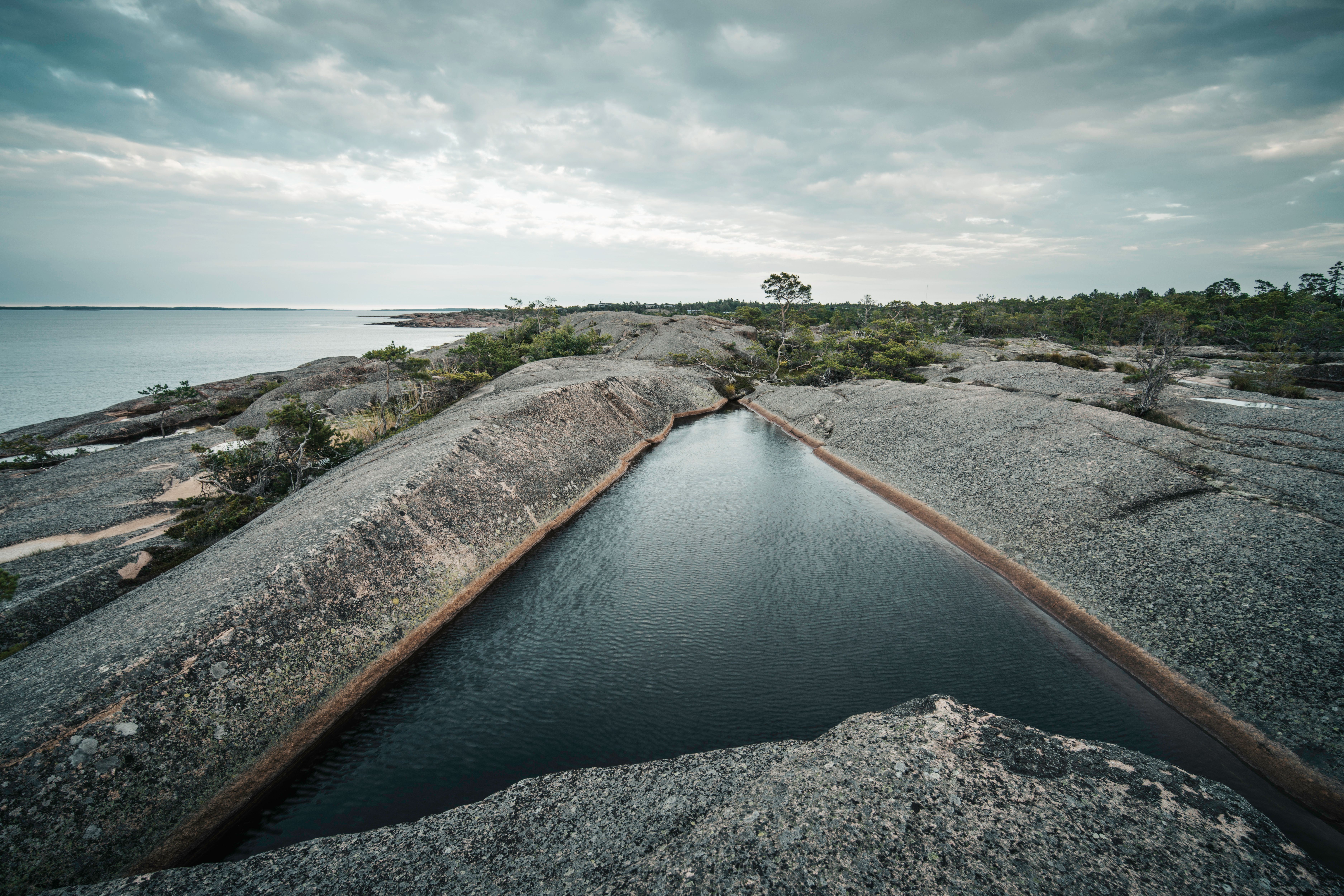 A tranquil rocky coastline with a natural water pool in the Åland Islands.