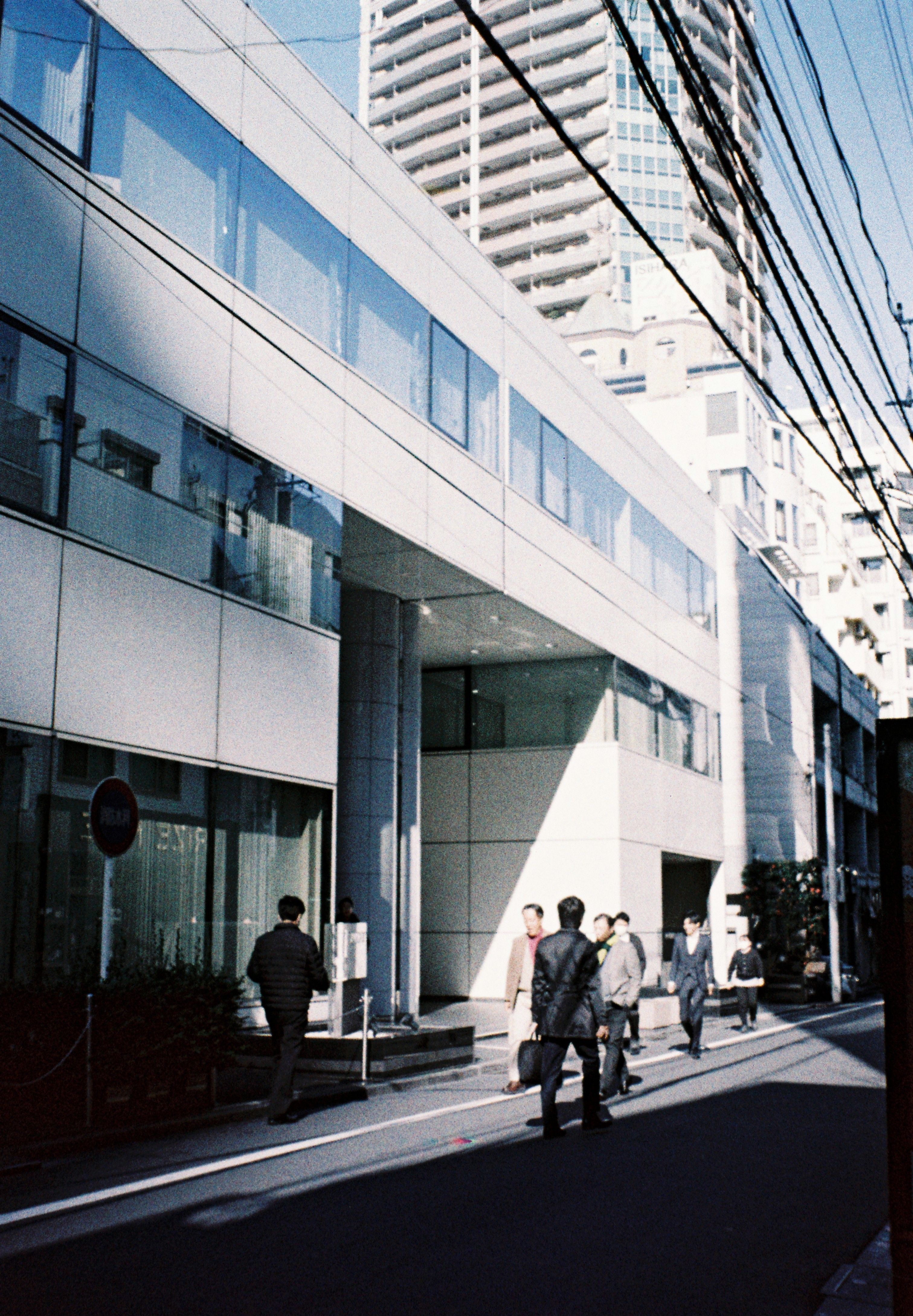 Street scene with pedestrians and modern buildings in Tokyo, Japan.