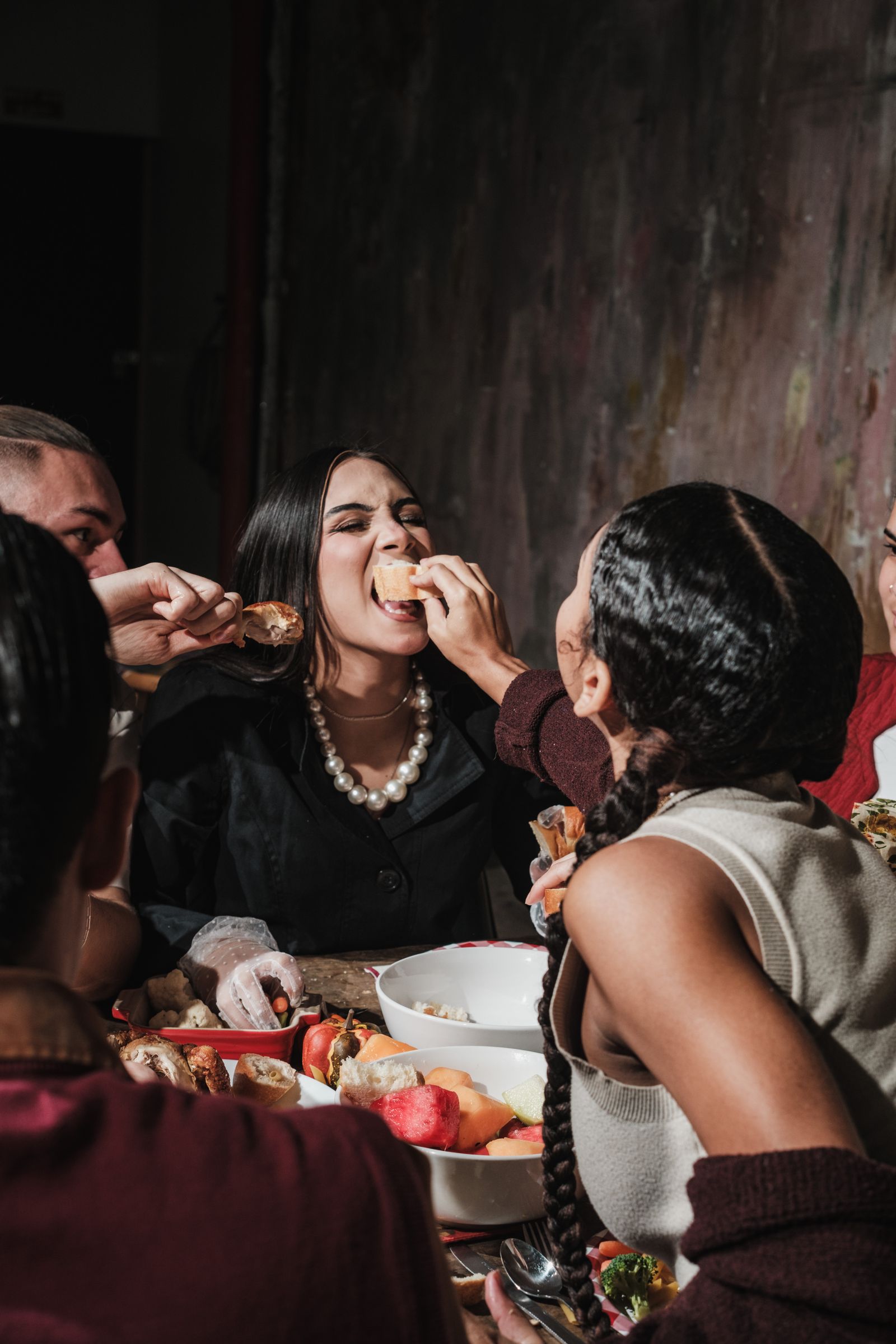 Group of friends laughing and sharing a festive meal together at a dinner table