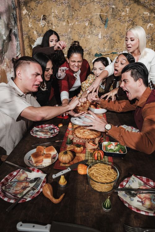 Free A lively group of adults sharing a festive Thanksgiving meal. Stock Photo