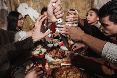 Free A group of friends sharing a lively Thanksgiving meal indoors. Stock Photo