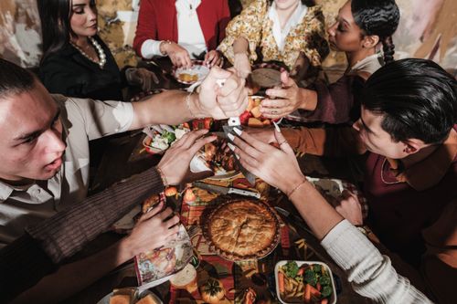 Free Join a diverse group enjoying a festive Thanksgiving dinner together. Stock Photo