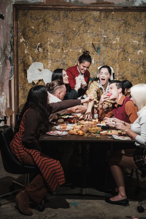 Free A joyful group of adults enjoying a festive dinner indoors, sharing food and laughter. Stock Photo