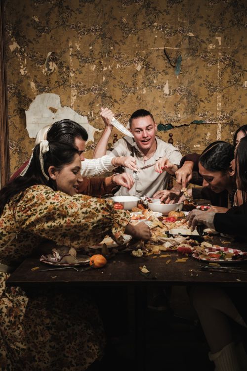 Free A group of friends sharing a joyful Thanksgiving dinner celebration indoors. Stock Photo