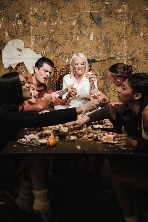 Free Group of adults enjoying a meal together in a rustic room, full of laughter and interaction. Stock Photo