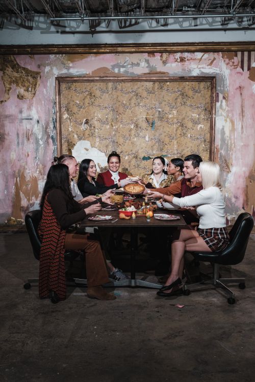 Free A diverse group of friends enjoying a festive dinner in an artistic indoor setting. Stock Photo