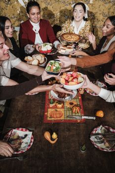 Diverse group celebrating Thanksgiving with a shared festive meal.