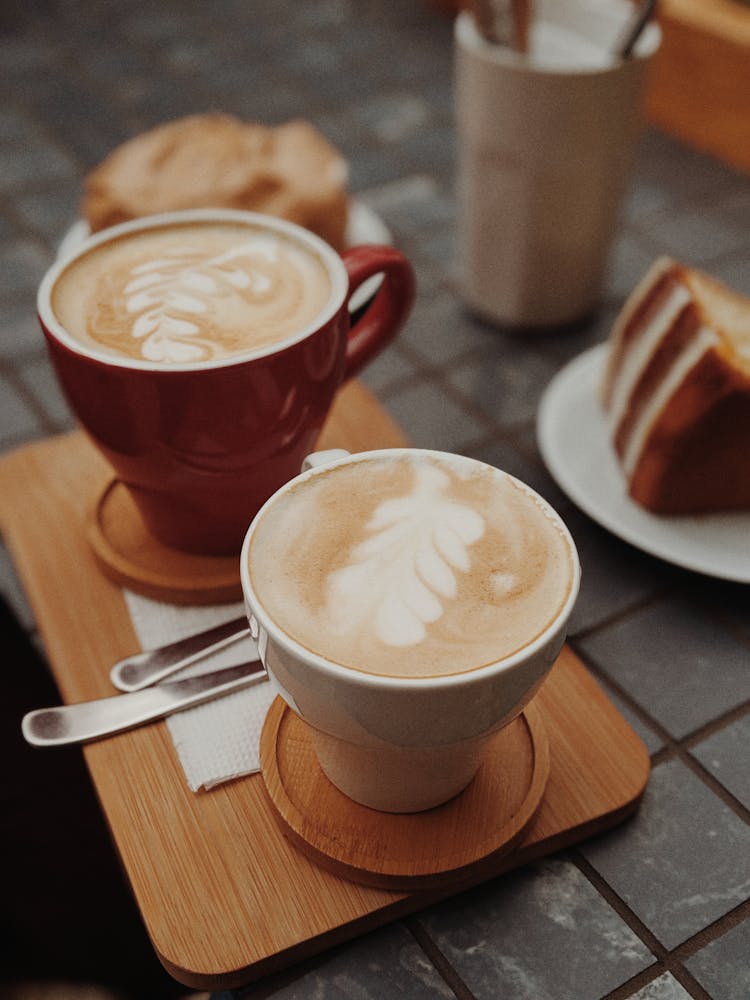 Two Cups Of Brown Coffee On Top Of Brown Tray