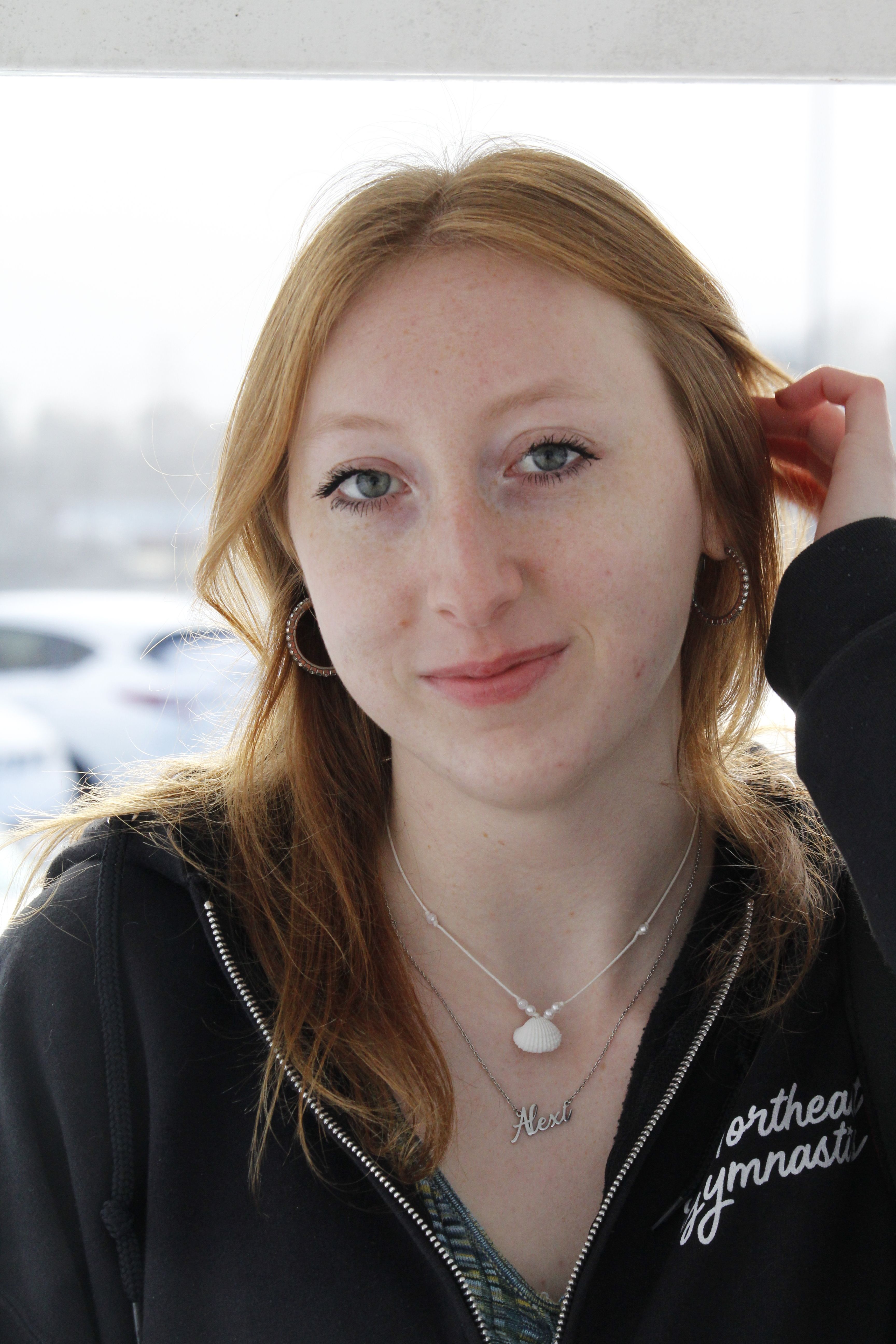 Charming portrait of a young woman with red hair outdoors, exuding warmth and confidence.