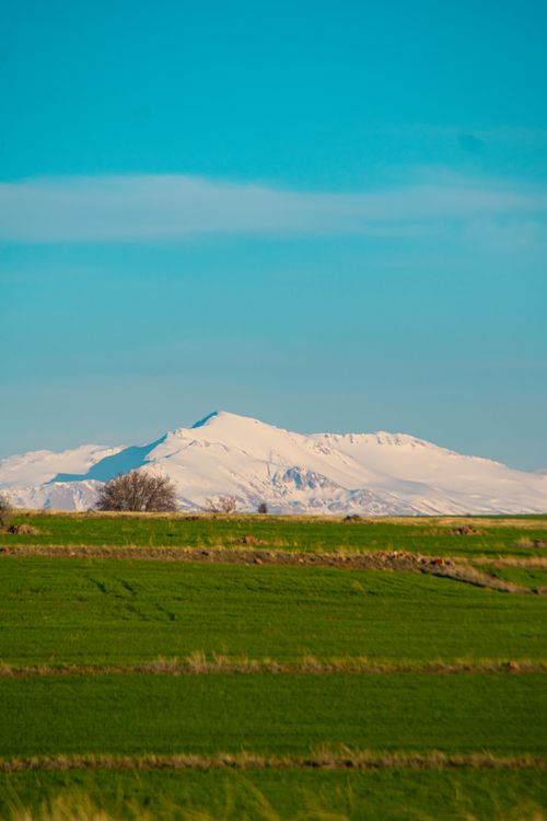 Free Beautiful snowy mountains with green fields in Ardıç, Kayseri, Türkiye. Stock Photo