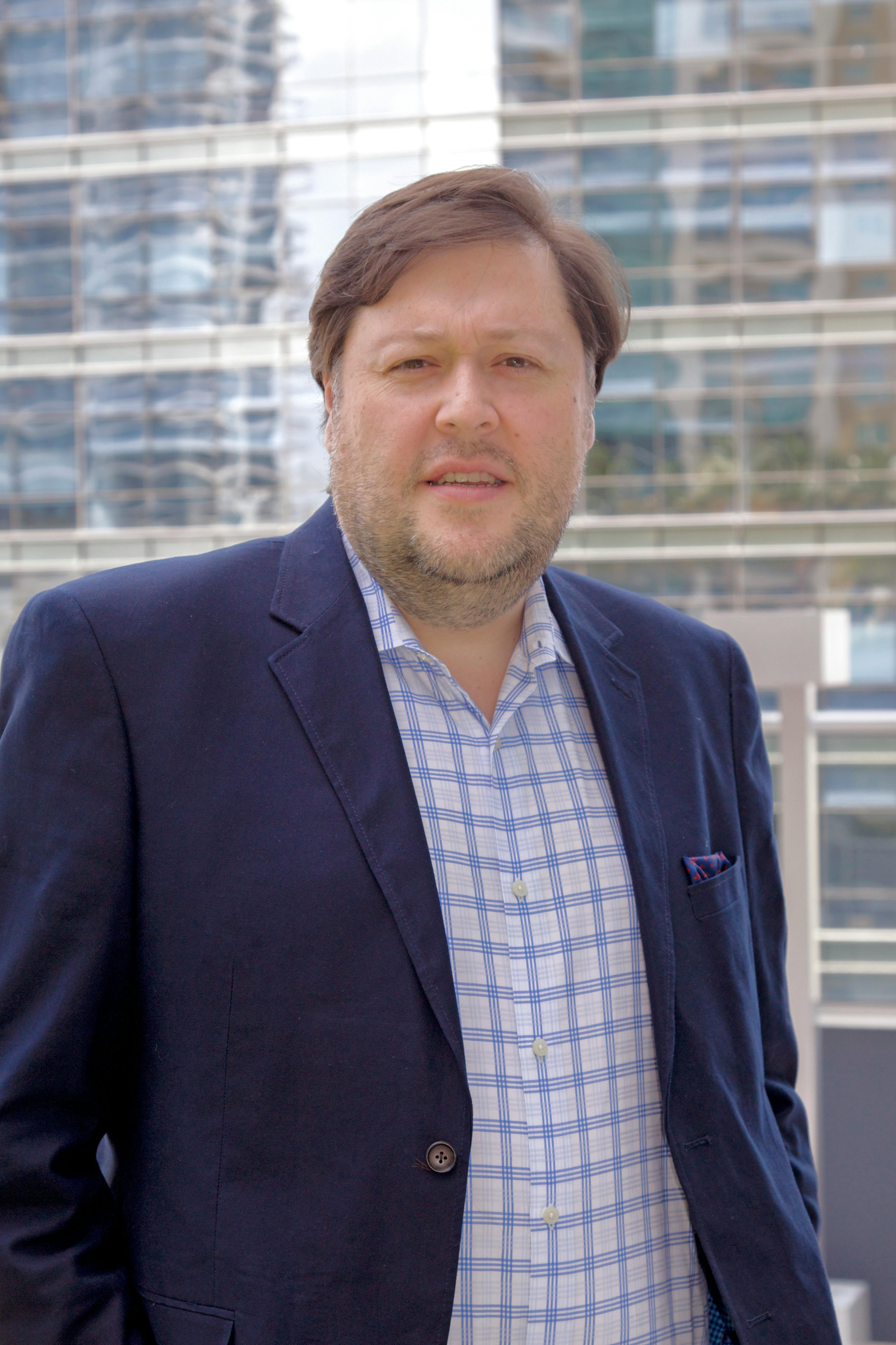 Portrait of a businessman in a formal suit with a modern city backdrop.