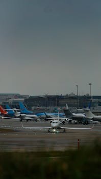 Multiple commercial airplanes parked at a bustling airport tarmac ready for takeoff.