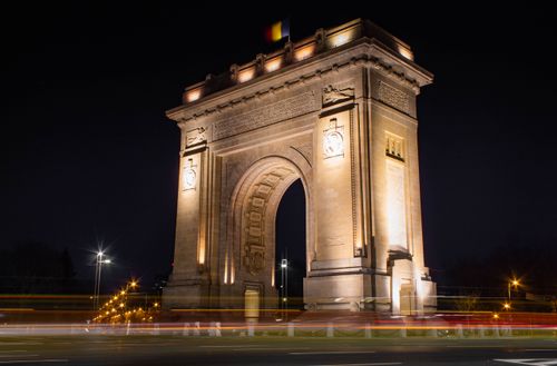 Free Illuminated Triumphal Arch in Bucharest, Romania, captured at night. Stock Photo