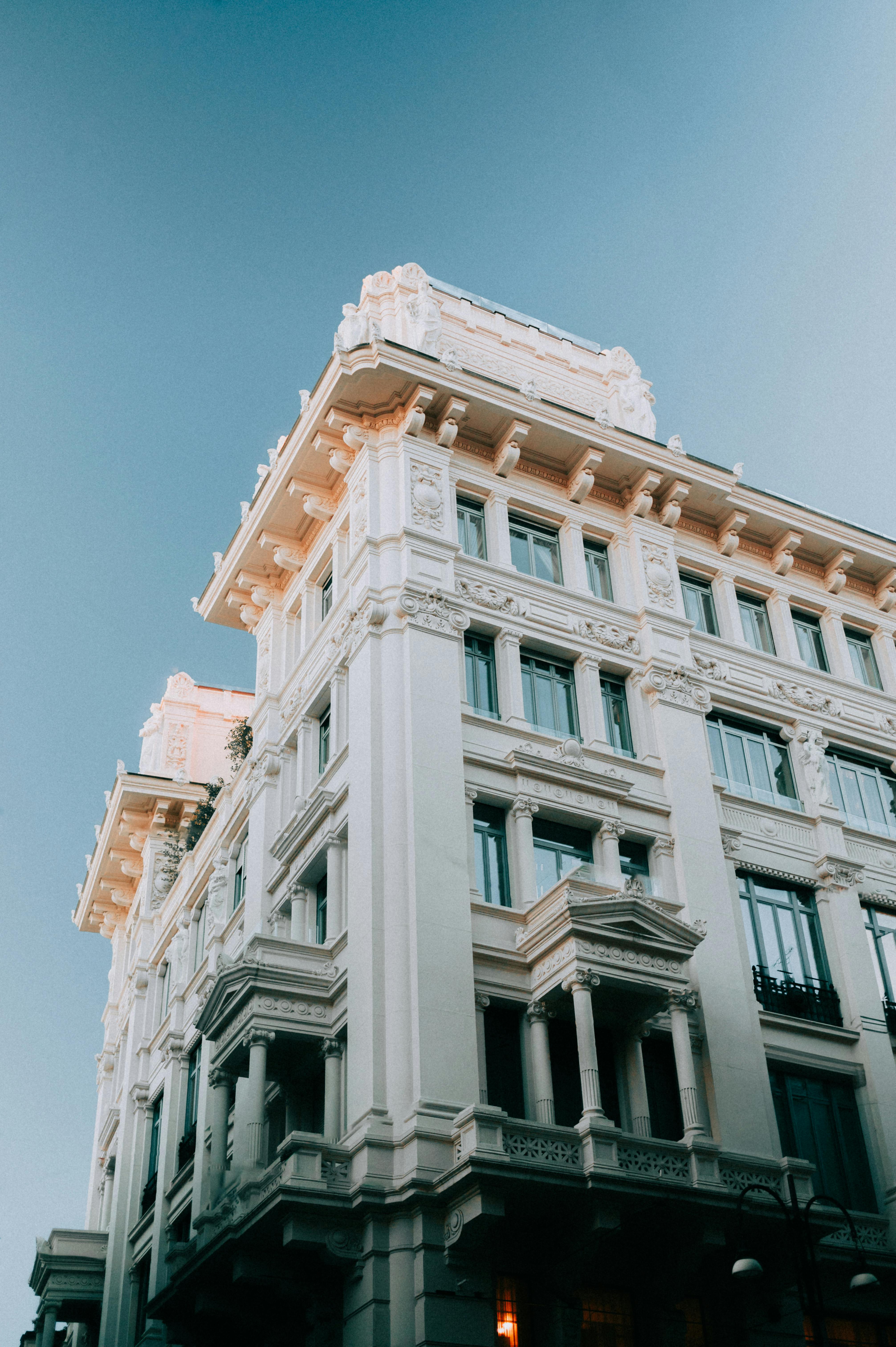 Striking view of a classic white building with intricate architecture against a clear blue sky.