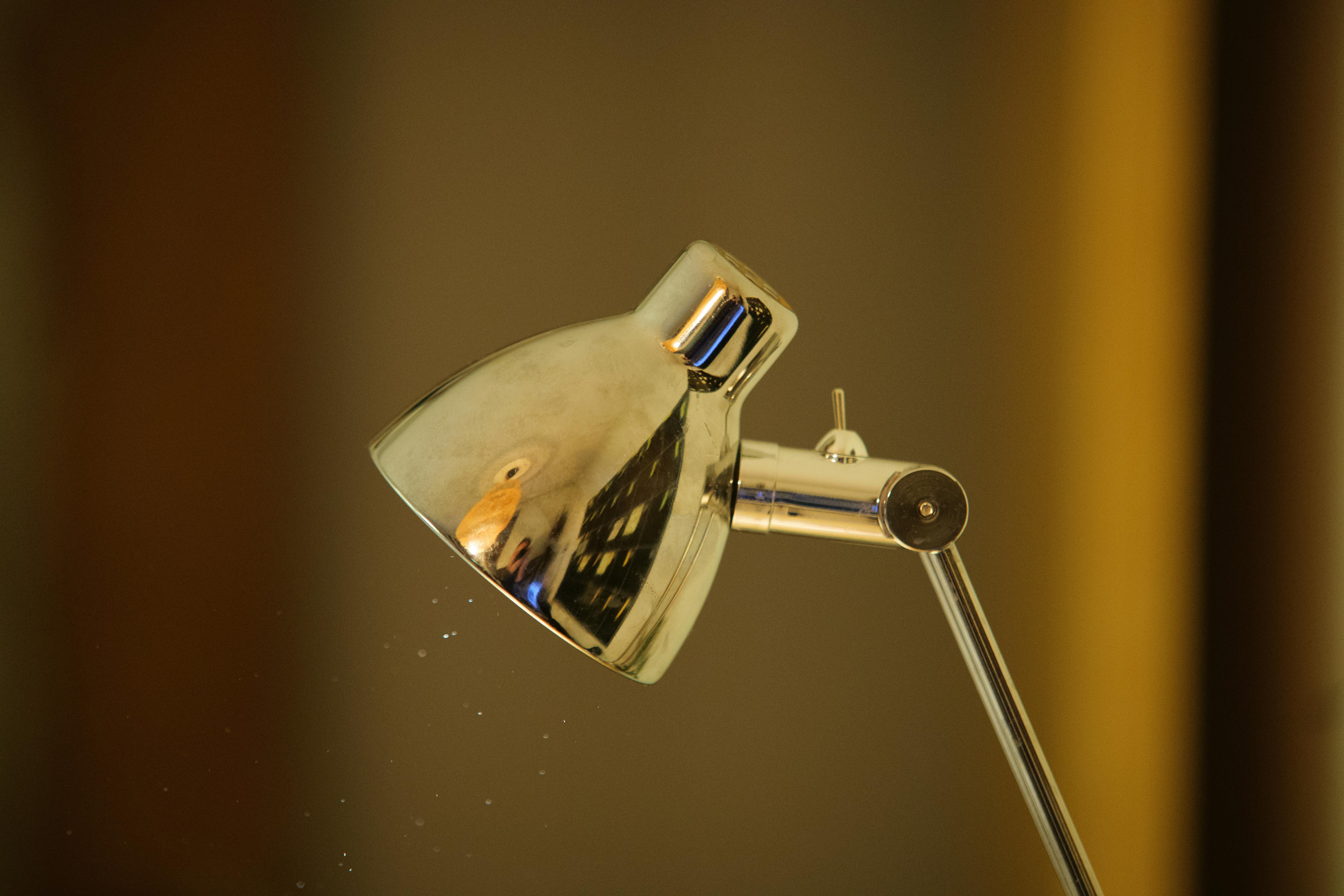 Zadarmo Detailný obrázok elegantnej kovovej stolovej lampy s odrazom vo vnútornom osvetlení. Fotka z fotobanky