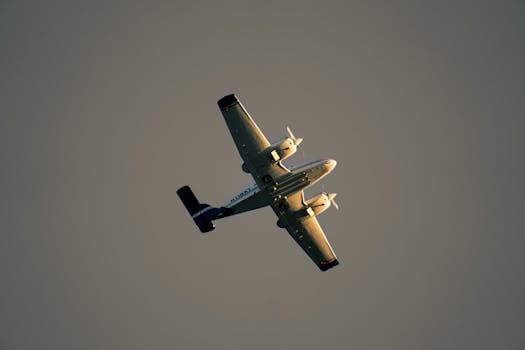 An airplane captured in flight against a minimalistic gray sky, highlighting aviation elegance.