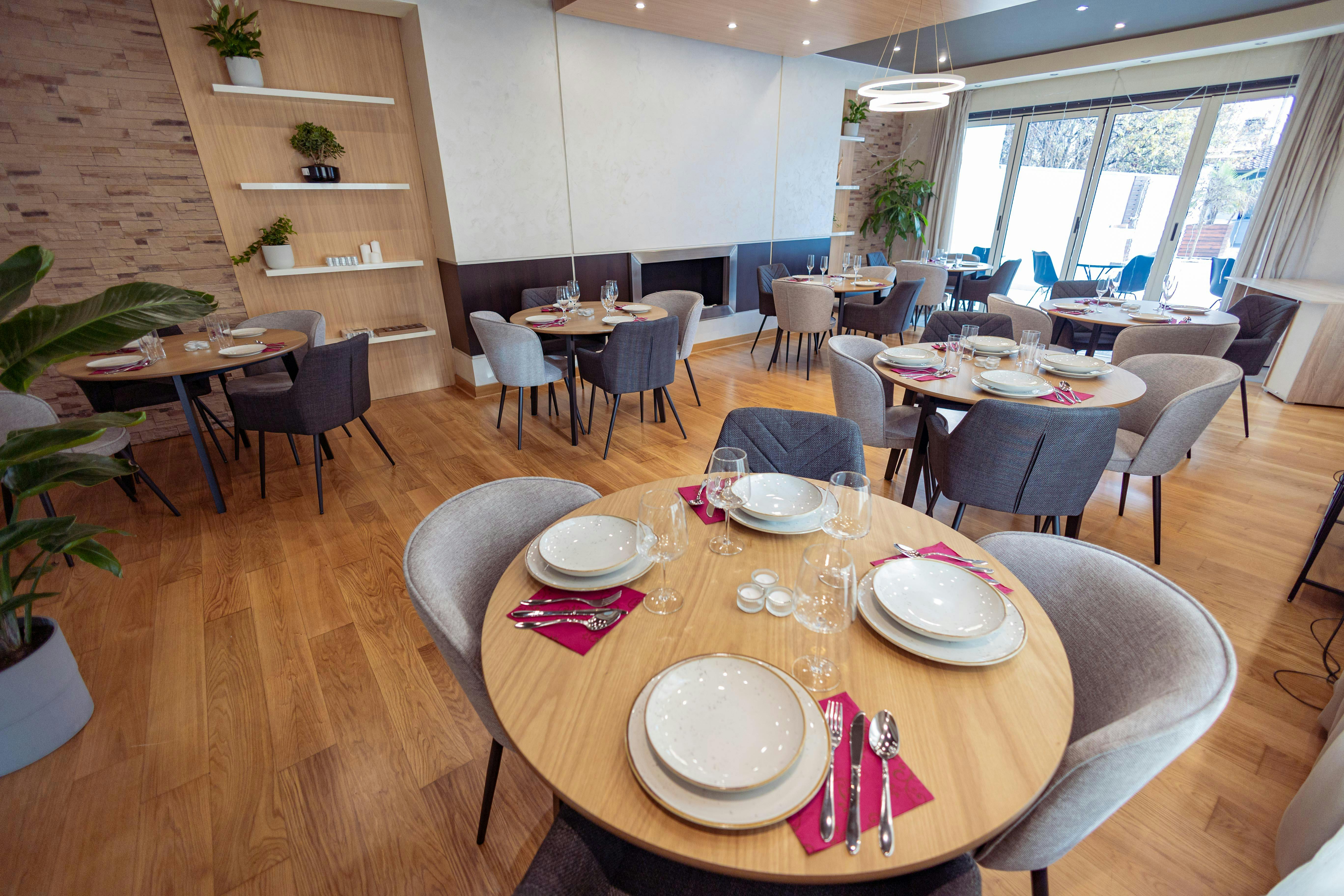 Free Sophisticated restaurant interior featuring round tables, elegant decor, and stylish seating arrangements. Stock Photo