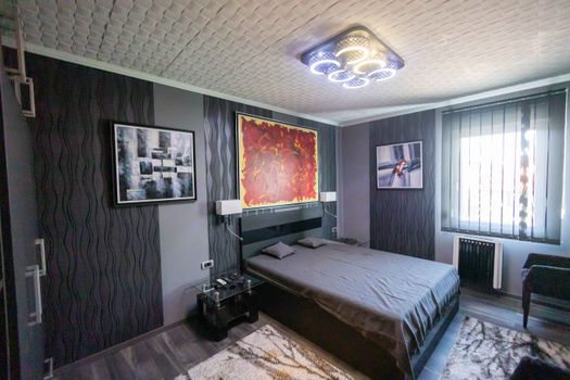 Contemporary bedroom design featuring dark tones and artistic wall decor.
