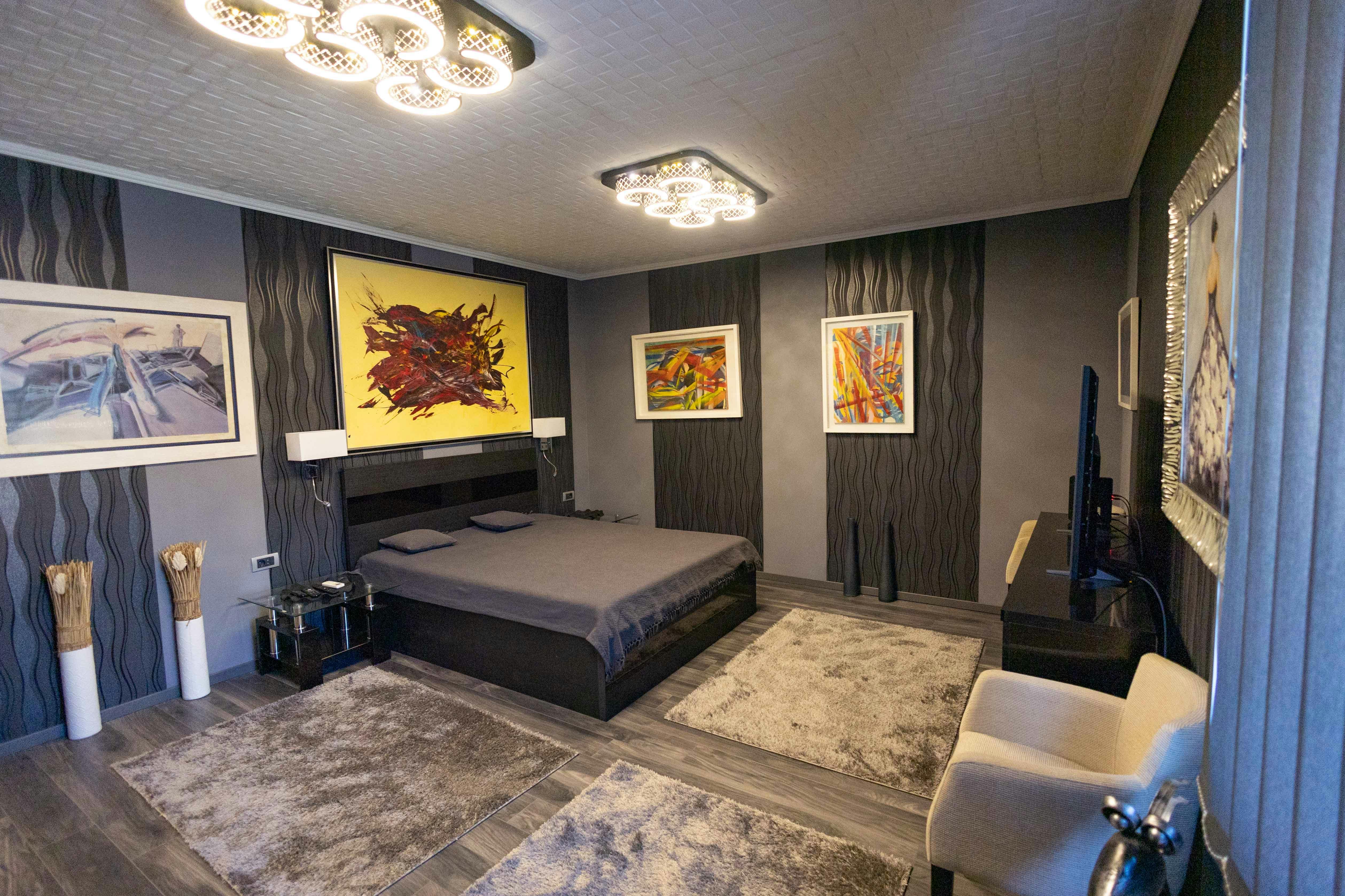 Free Stylish modern bedroom with abstract wall art and elegant lighting. Stock Photo