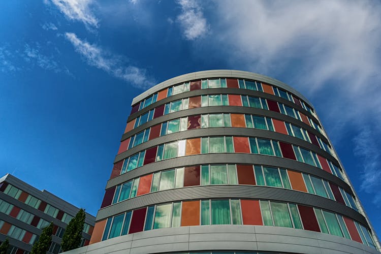 Curved Building With Big Windows And Brown Panels