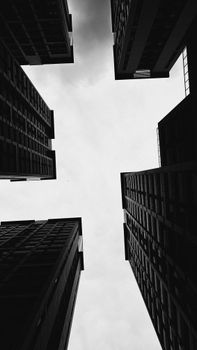 A stark black and white photo capturing dramatic urban skyscrapers from below.