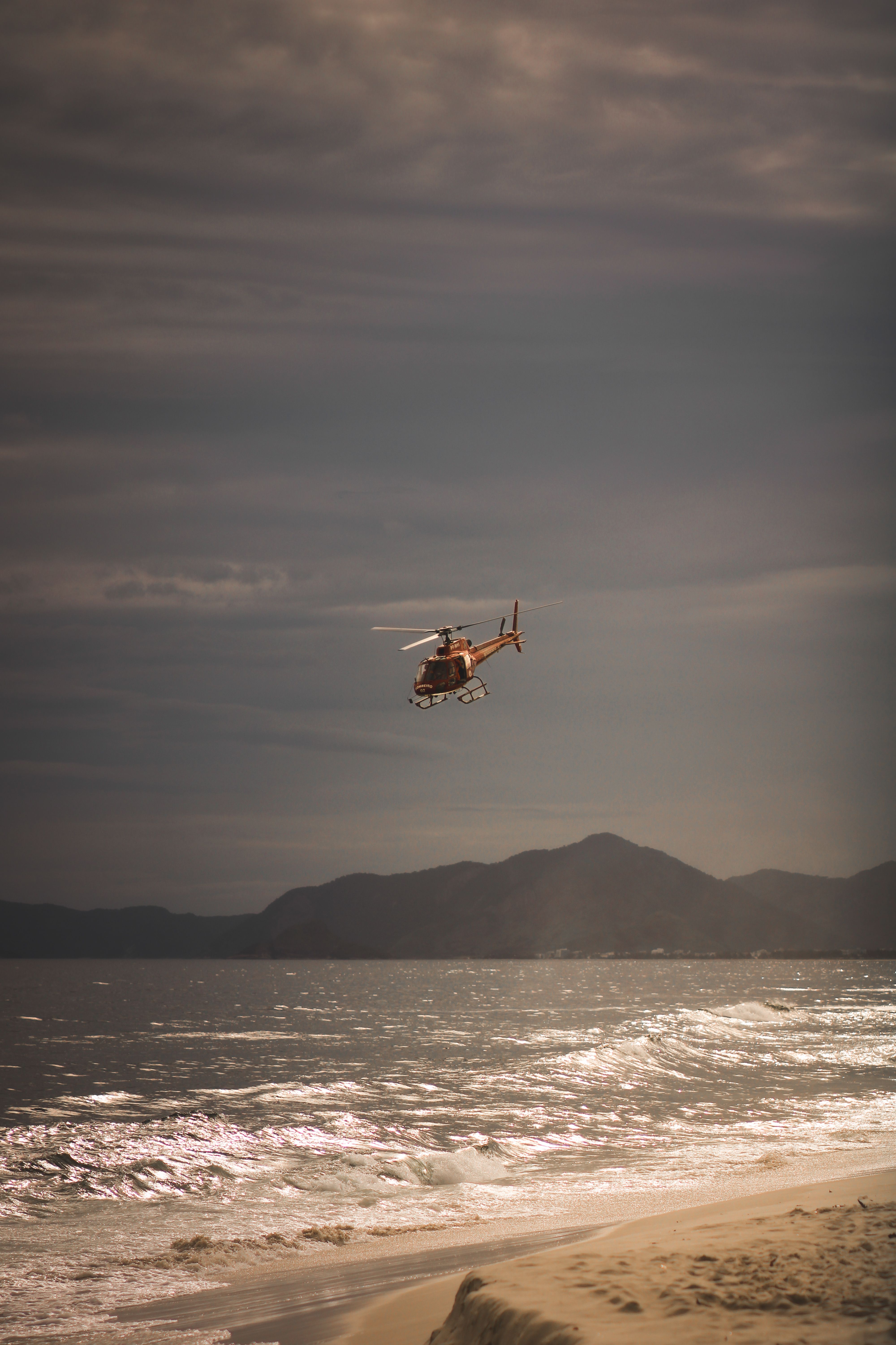 Aerial Helicopter Over Ocean at Sunset · Free Stock Photo