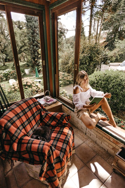 책을 읽는 동안 창틀에 앉아 여자