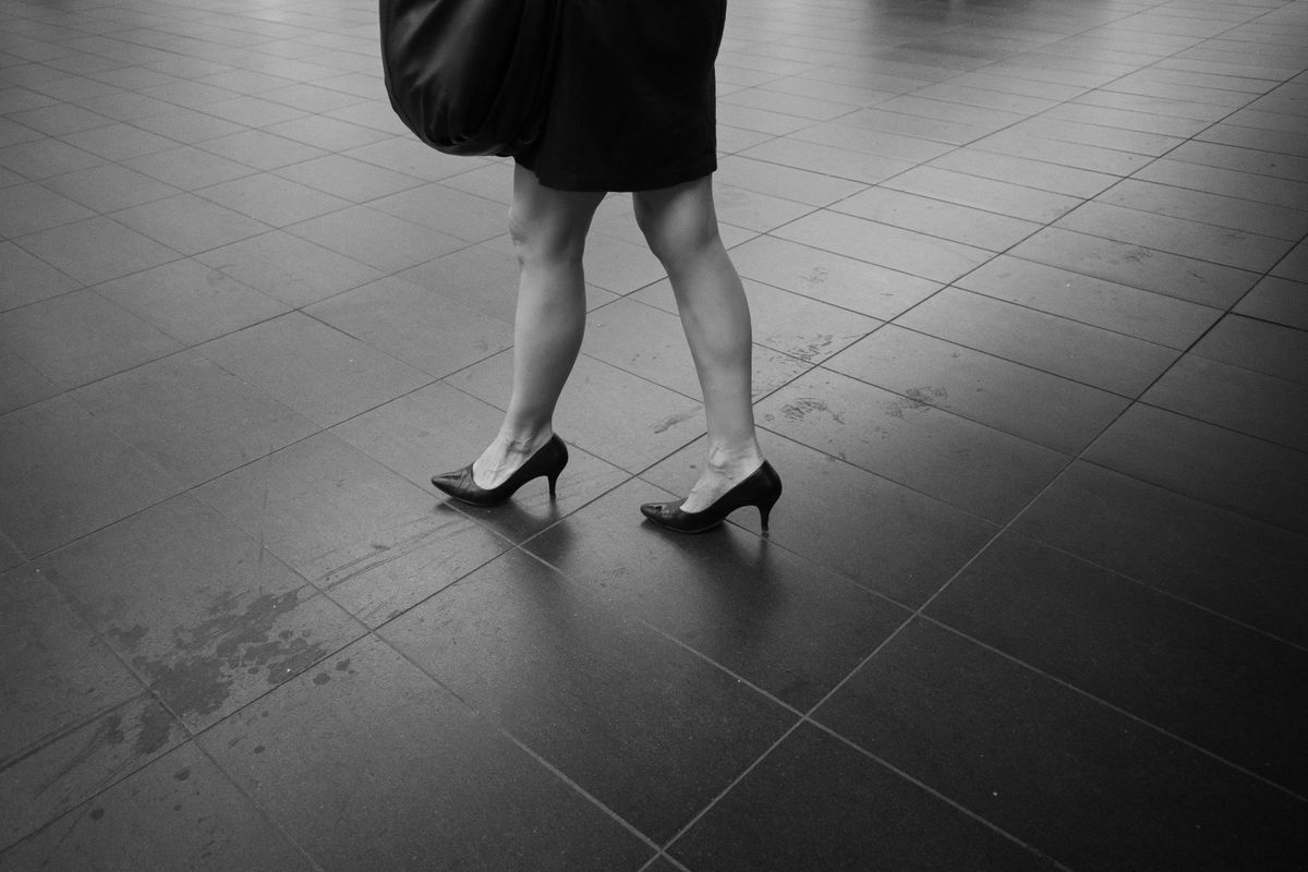 Vrouw loopt op pumps over een stoep in de stad