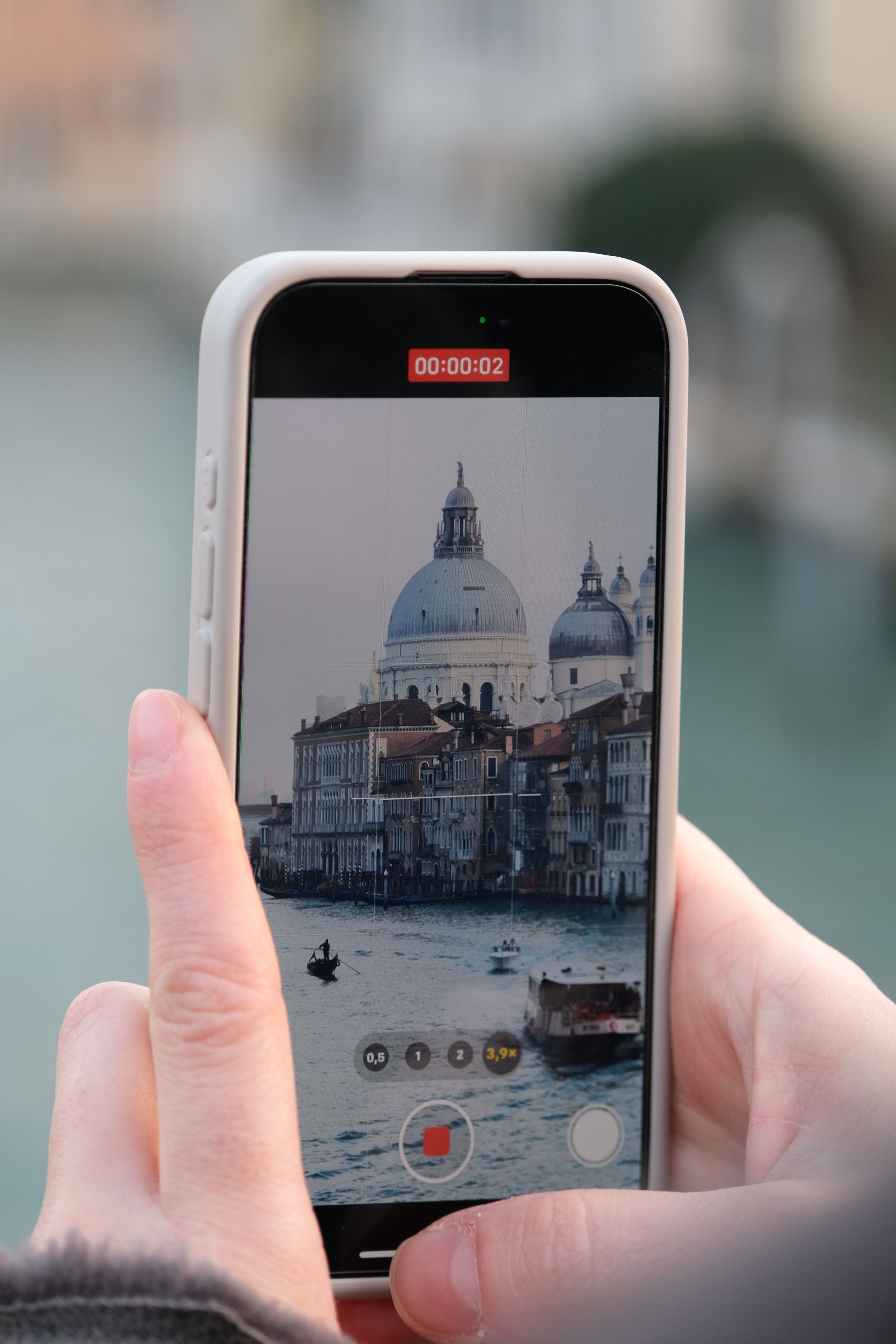 A close-up view of Venice's Grand Canal captured on a smartphone, showcasing historic architecture.