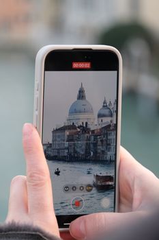 A close-up view of Venice's Grand Canal captured on a smartphone, showcasing historic architecture.