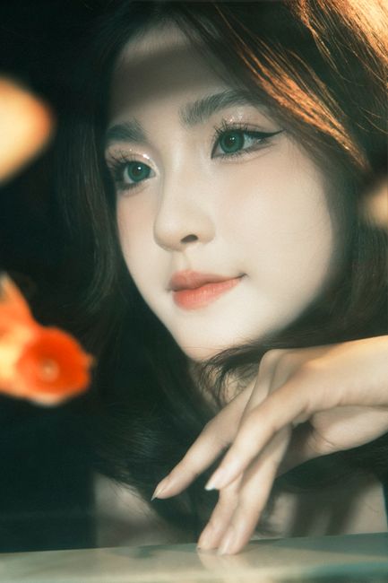 Elegant portrait of a woman with gentle expression, reflecting tranquility with koi fish.