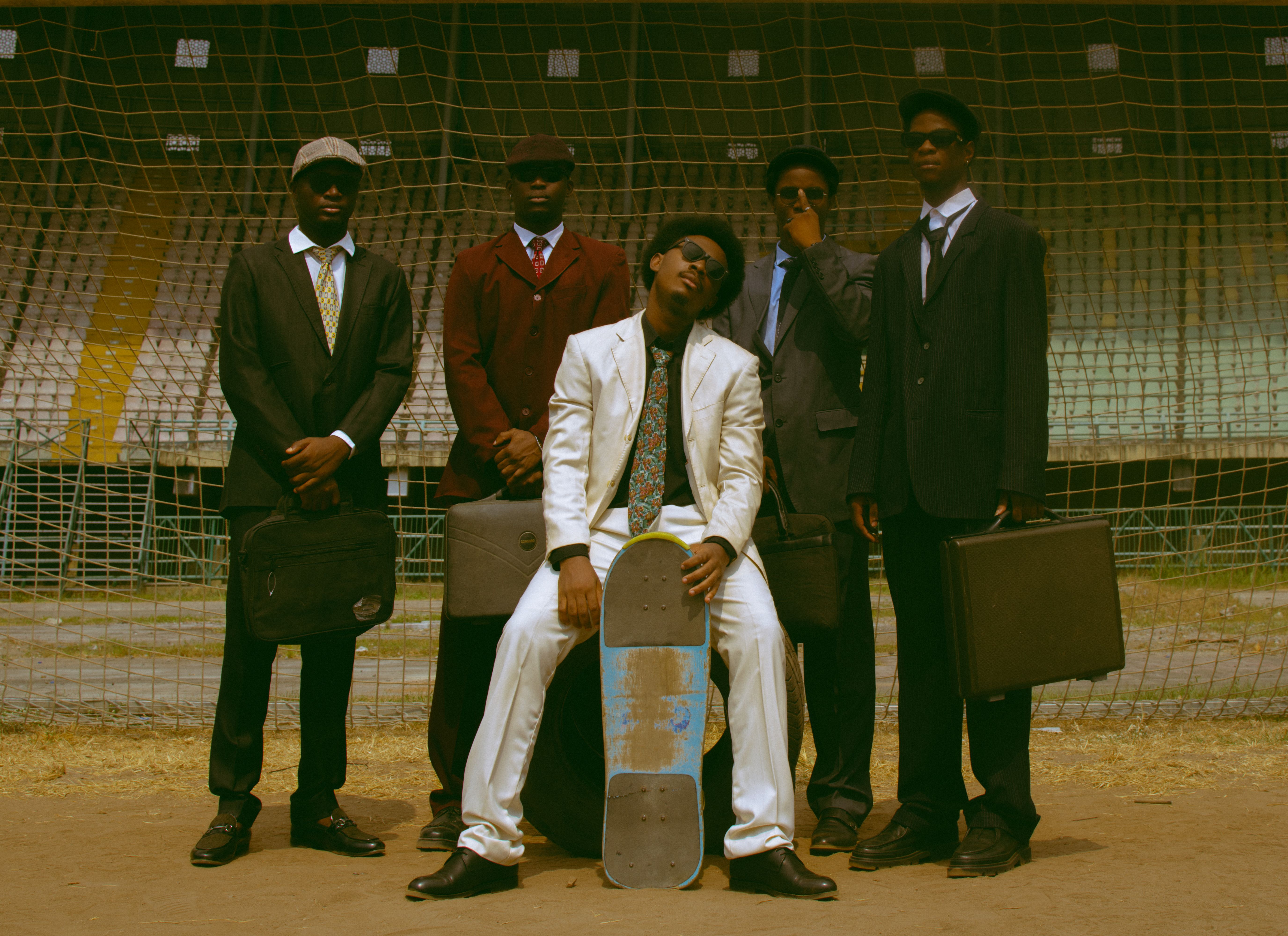 Group of Stylish Men in Suits with Skateboard Outdoors · Free Stock Photo