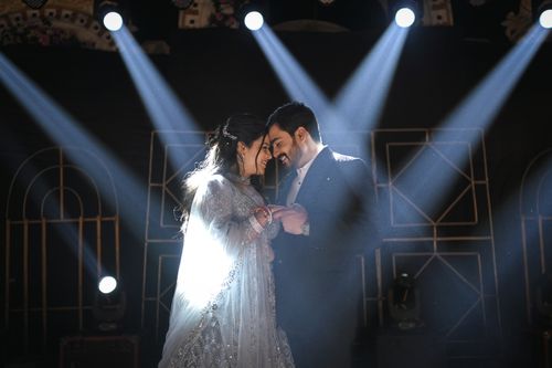Free A smiling couple enjoys a romantic dance under dramatic spotlights. Stock Photo
