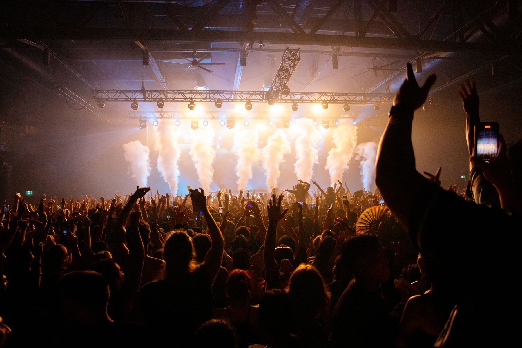 Crowd lit by moving lights at a night show — photo by Jeremy Li on Pexels