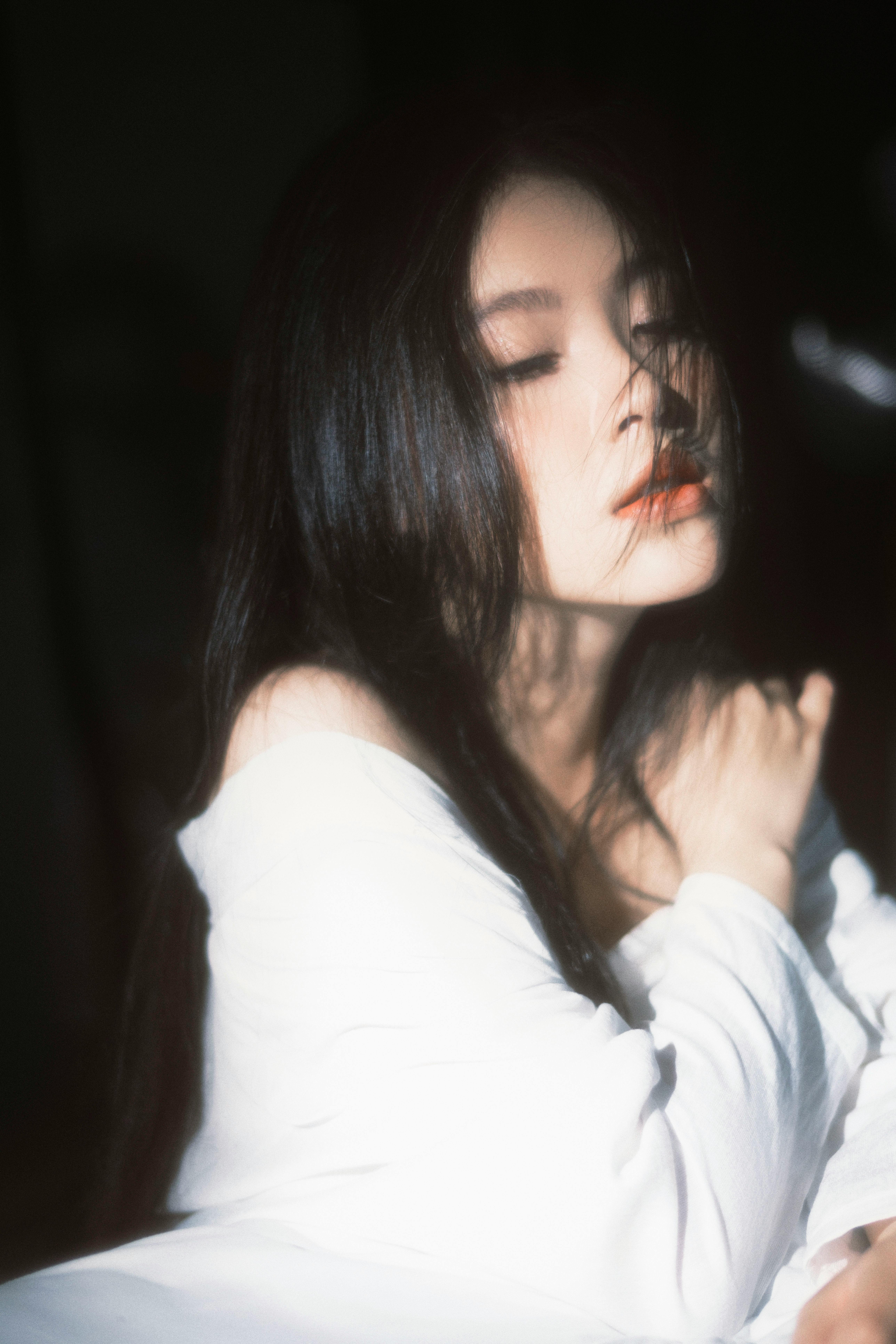 Intimate portrait of woman in soft light, eyes closed in deepening relaxation and trust