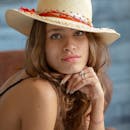 一位棕色头发的妇女，戴着时尚的遮阳帽，在室内的肖像