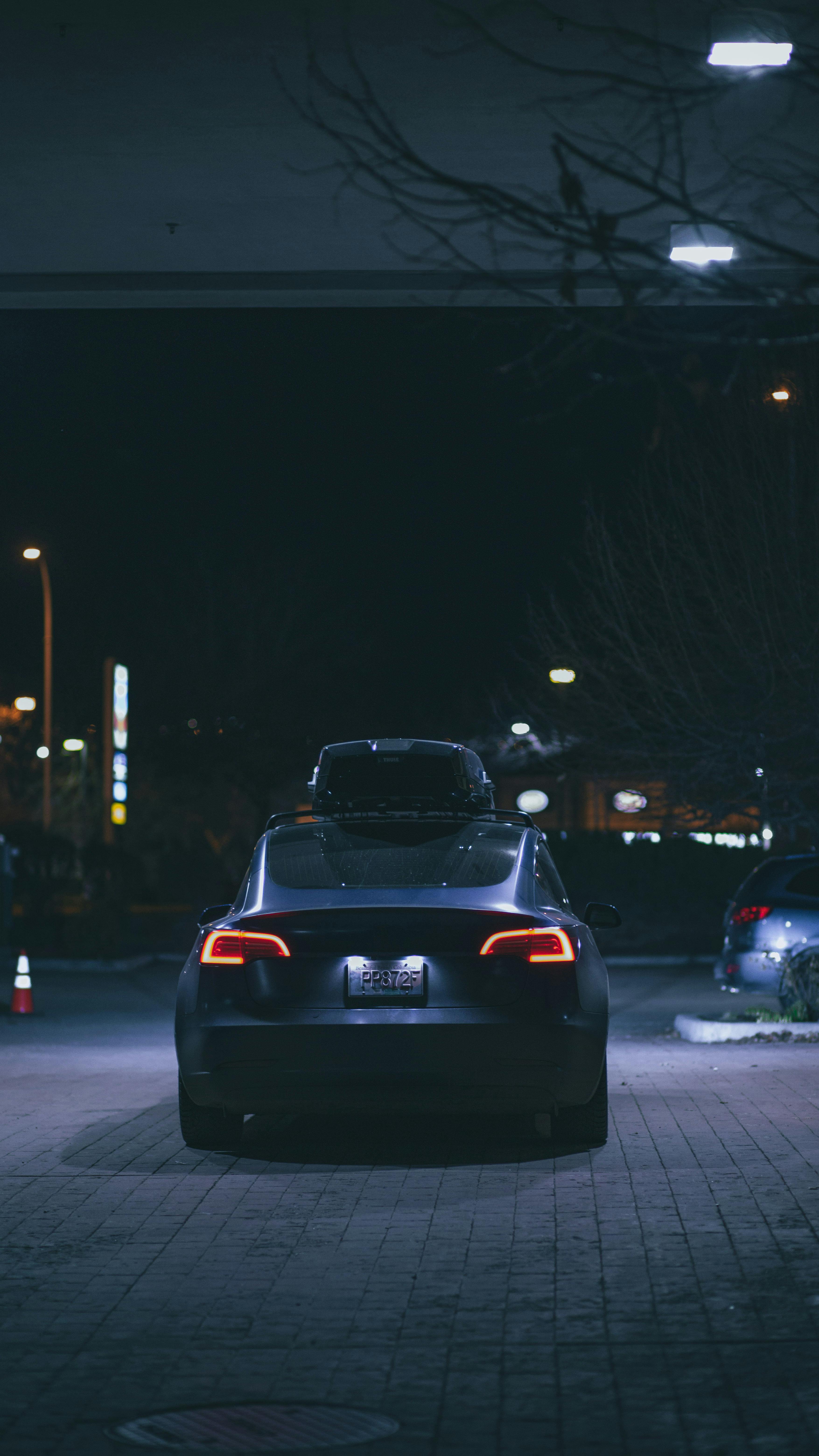 Free Stylish electric vehicle parked outdoors at night, illuminated by streetlights. Stock Photo