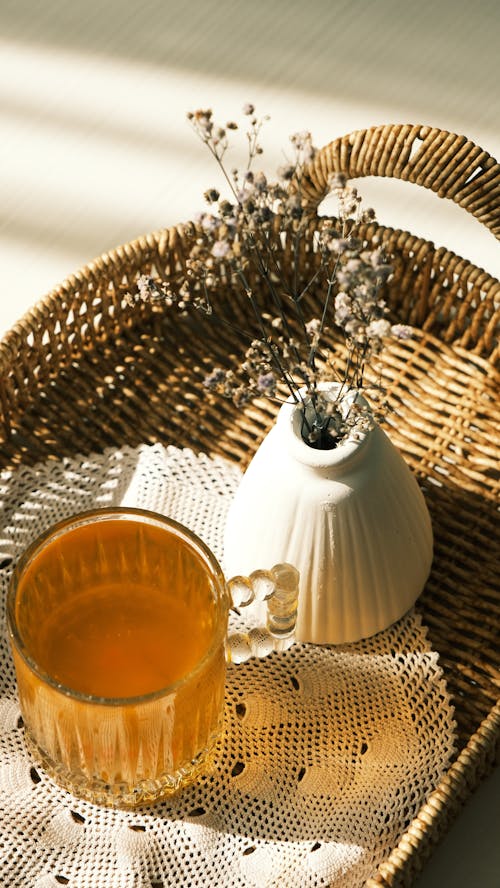 Free Warm afternoon setup with herbal tea and dried flowers in wicker basket. Stock Photo