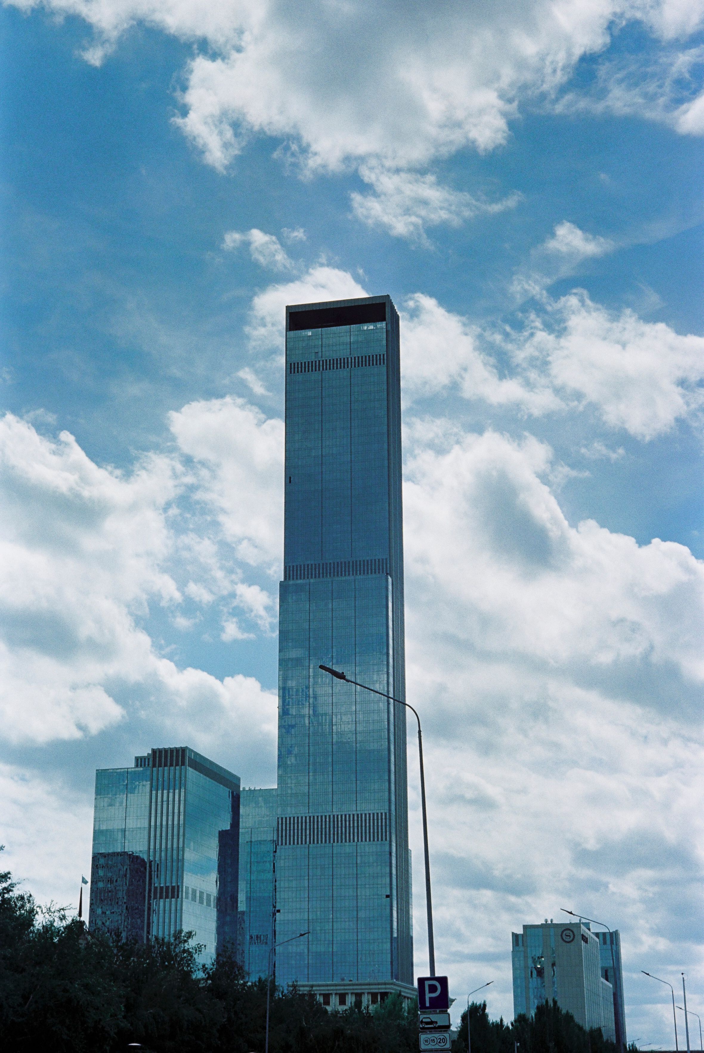 Tall modern skyscrapers against a bright blue sky, capturing Astana's urban architecture.