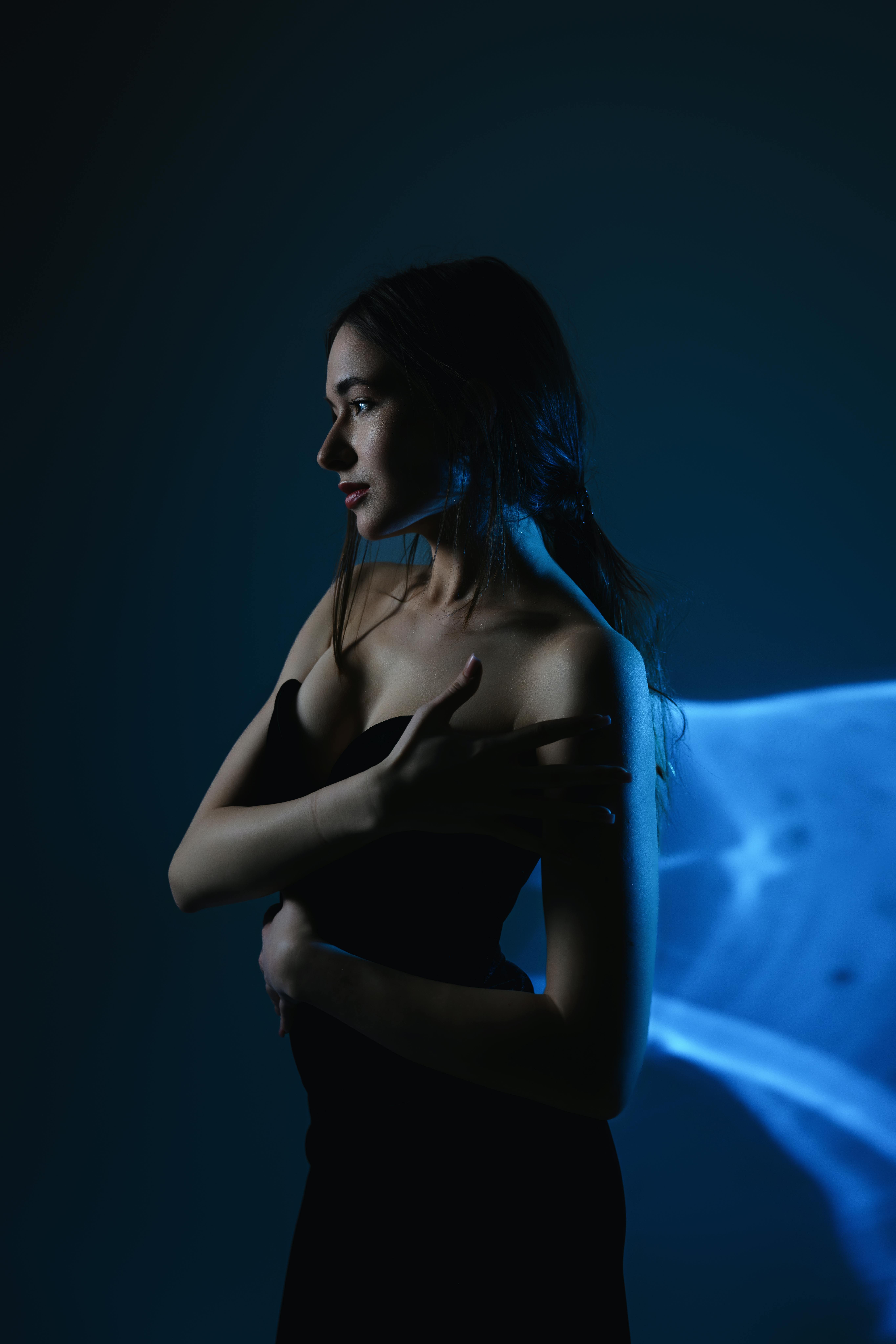 An elegant female model poses with ethereal lighting in a studio setting in London.