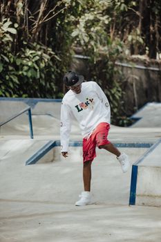 Teenager enjoying skateboarding outdoors at a sunny skate park.